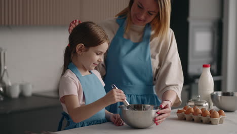 mom-and-daughter-are-cooking-together-in-home-kitchen-little-girl-and-her-mother-are-mixing-ingredients-in-bowl